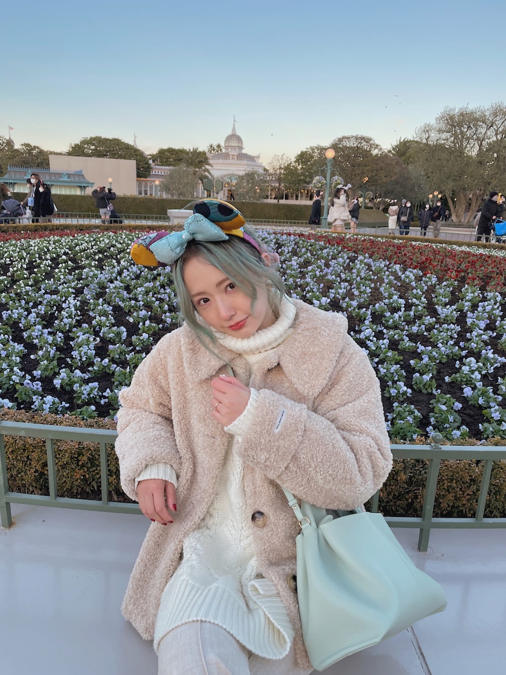 ベージュ系のジャケット/アウター、ホワイト系のニット/セーター、グリーン系のバッグを着用したレディースの冬コーディネートの3枚目の写真