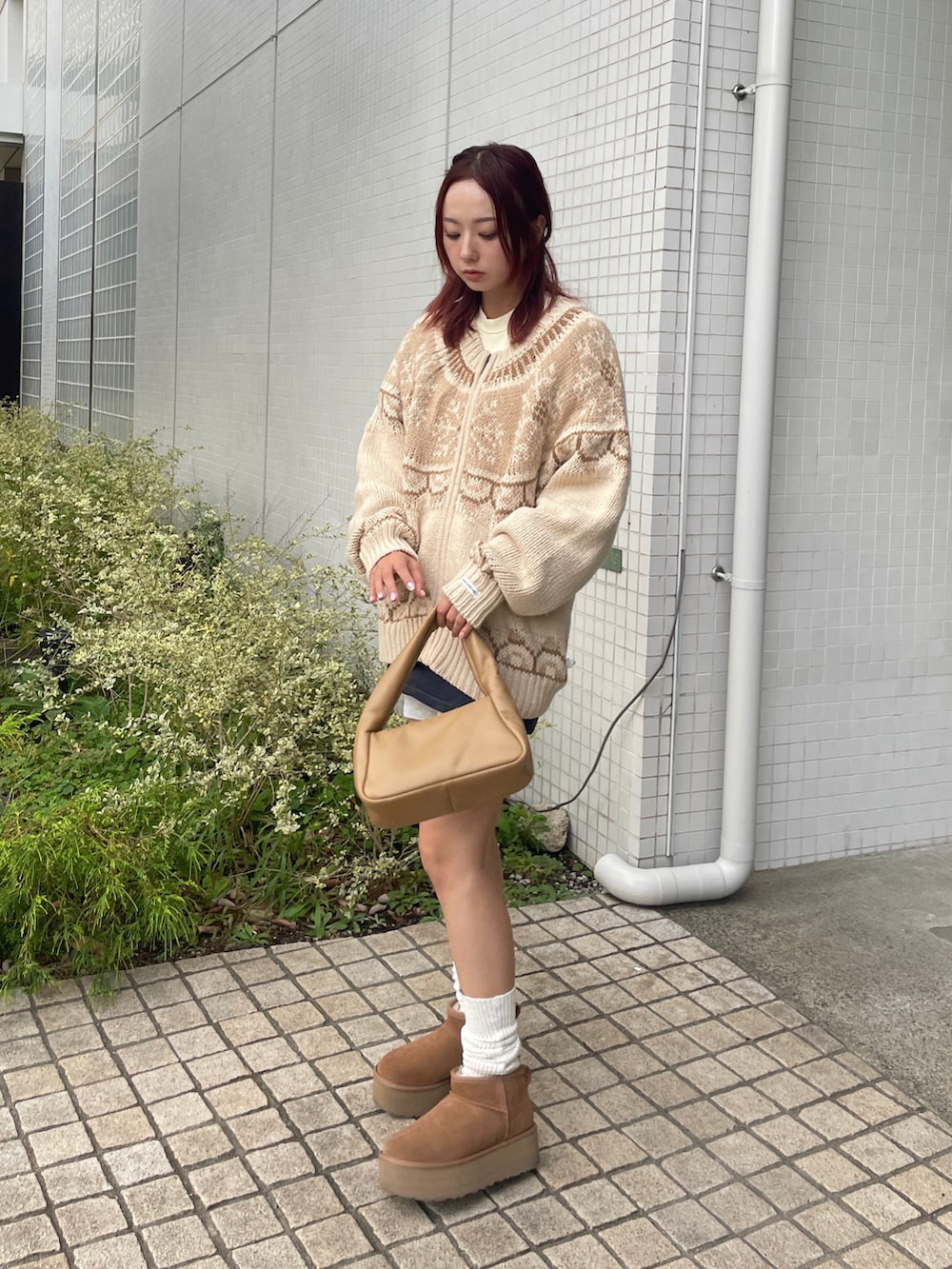 ブルー系のデニムスカート、イエロー系のショルダーバッグ、イエロー系のブーツを着用したレディースの秋コーディネートの2枚目の写真