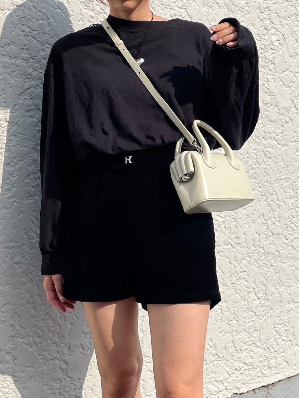 ベージュ系のショルダーバッグ、ブラック系のスニーカー、ブラック系のその他パンツを着用したレディースの秋コーディネートの3枚目の写真