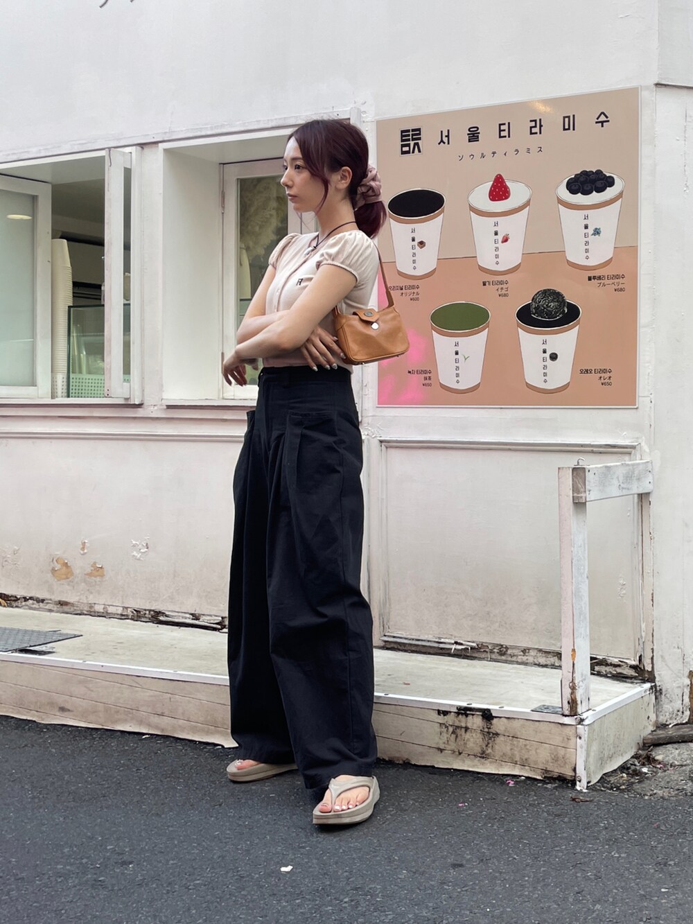 ブラック系のその他パンツ、ベージュ系のサンダル、ブラウン系のハンドバッグを着用したレディースの夏コーディネートの2枚目の写真