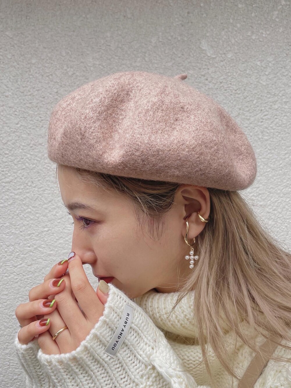 ホワイト系のニット/セーター、ベージュ系のバッグ、ベージュ系のスカートを着用したレディースの冬コーディネートの4枚目の写真