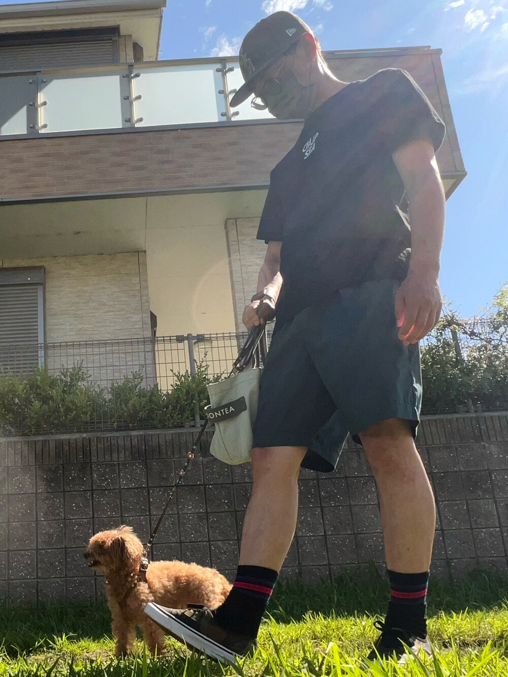 ブラック系のTシャツ/カットソー、グリーン系のチノパンツ、グリーン系のスニーカーを着用したメンズの夏コーディネートの2枚目の写真
