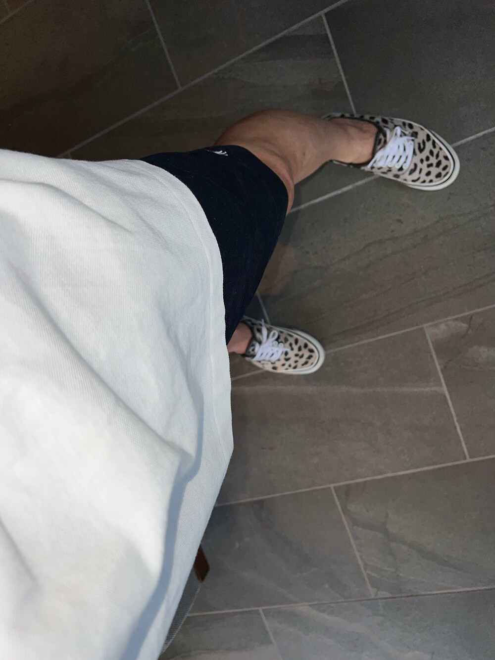 ブルー系のチノパンツ、ホワイト系のポロシャツ、ブラック系のトートバッグを着用したメンズの夏コーディネートの4枚目の写真