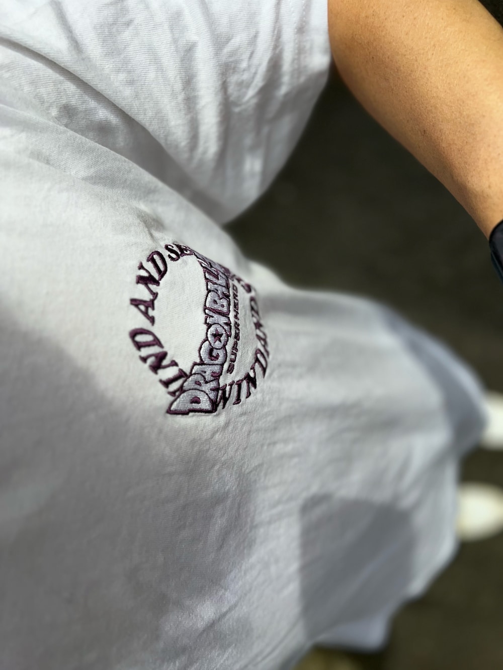 ブルー系のチノパンツ、ホワイト系のスニーカー、ホワイト系のTシャツ/カットソーを着用したメンズの春コーディネートの3枚目の写真