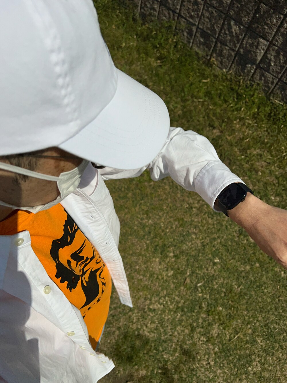 ブルー系のデニムパンツ、ホワイト系のシャツ/ブラウス、オレンジ系のTシャツ/カットソーを着用したメンズの春コーディネートの3枚目の写真