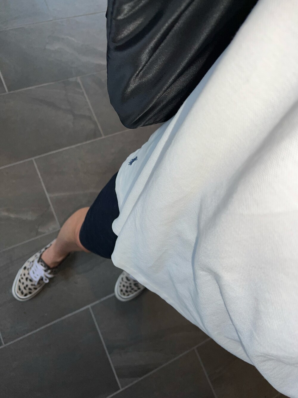 ブルー系のチノパンツ、ホワイト系のポロシャツ、ブラック系のトートバッグを着用したメンズの夏コーディネートの3枚目の写真