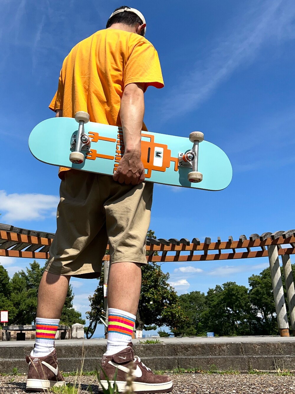 オレンジ系のTシャツ/カットソー、ベージュ系のその他パンツ、ブラウン系のスニーカーを着用したメンズの夏コーディネートの2枚目の写真