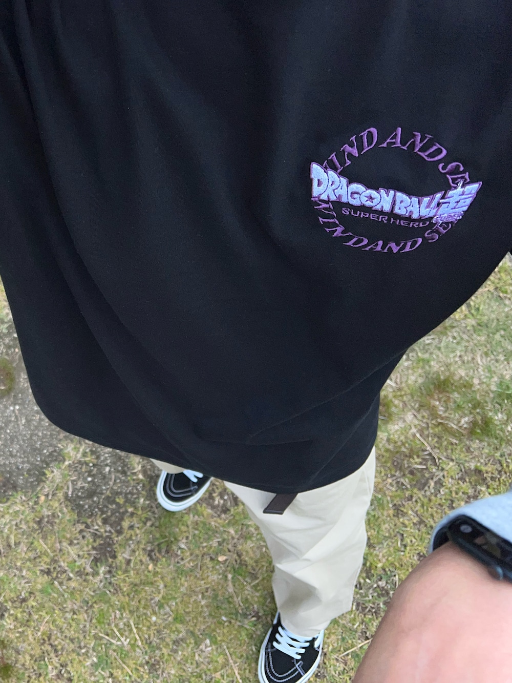 ベージュ系のチノパンツ、ブラック系のTシャツ/カットソー、ブラック系のスニーカーを着用したメンズの春コーディネートの3枚目の写真