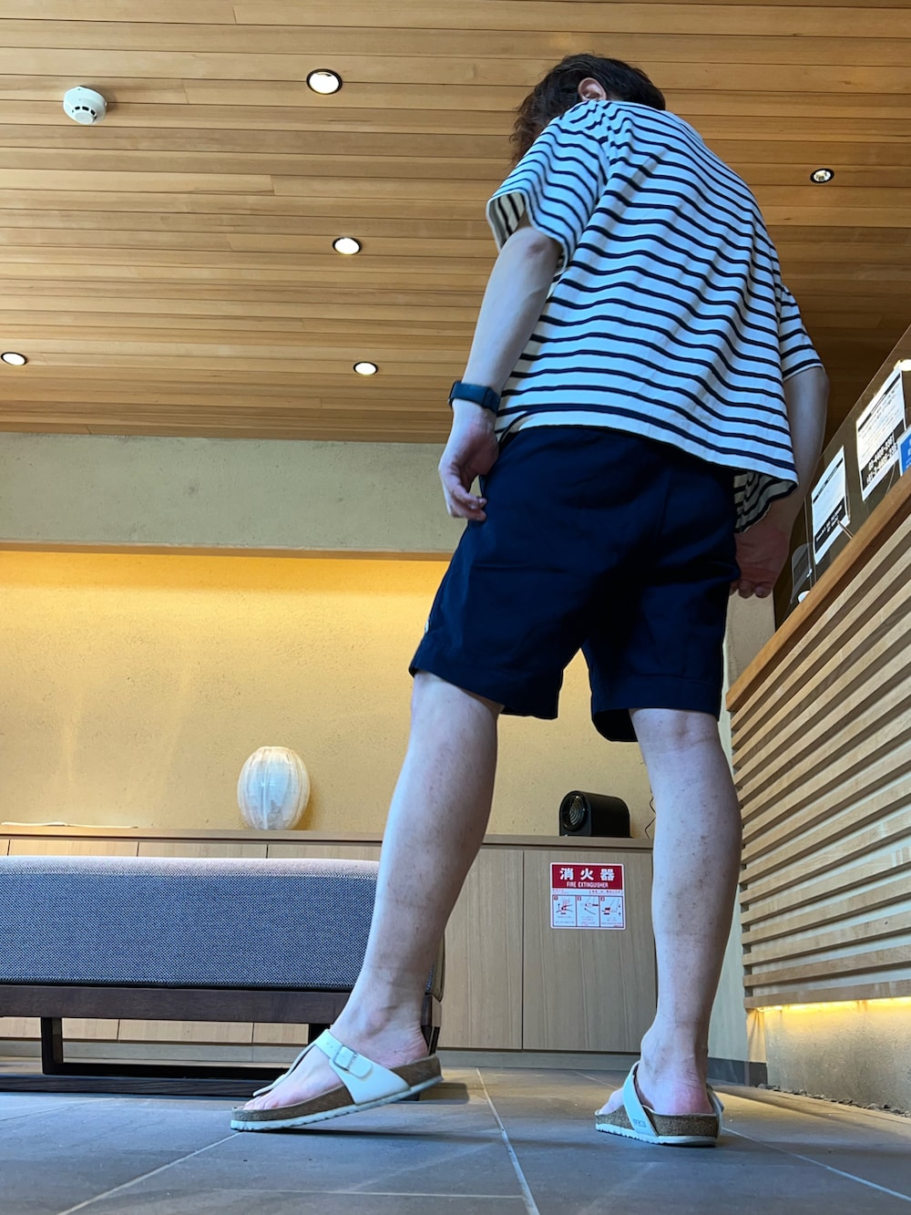 ブルー系のチノパンツ、ホワイト系のサンダル、ブルー系のTシャツ/カットソーを着用したメンズの夏コーディネートの2枚目の写真