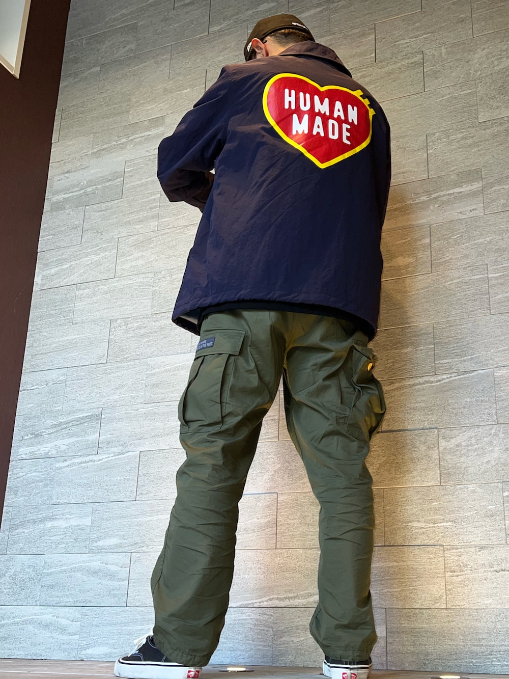 グリーン系のカーゴパンツ、ブラック系のTシャツ/カットソー、ブルー系のナイロンジャケットを着用したメンズの秋コーディネートの2枚目の写真