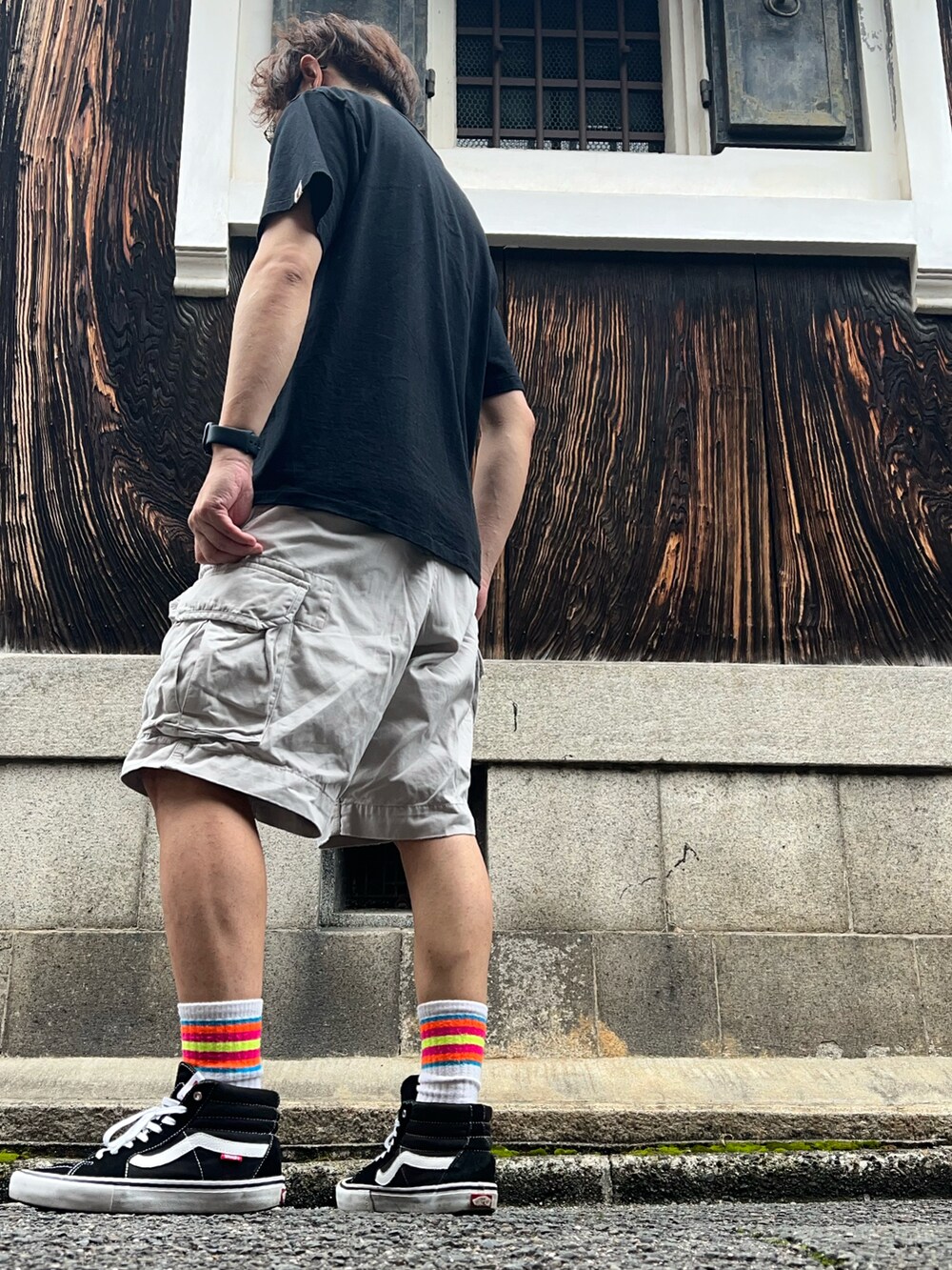 ブラック系のTシャツ/カットソー、ベージュ系のカーゴパンツ、ブラック系のスニーカーを着用したメンズの夏コーディネートの2枚目の写真