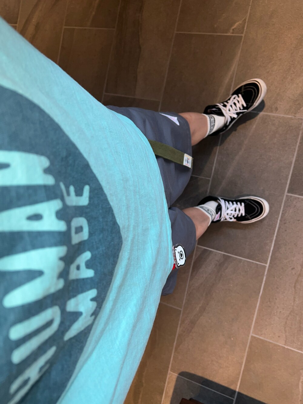 グレー系のその他パンツ、グリーン系のTシャツ/カットソー、ブラック系のスニーカーを着用したメンズの夏コーディネートの3枚目の写真