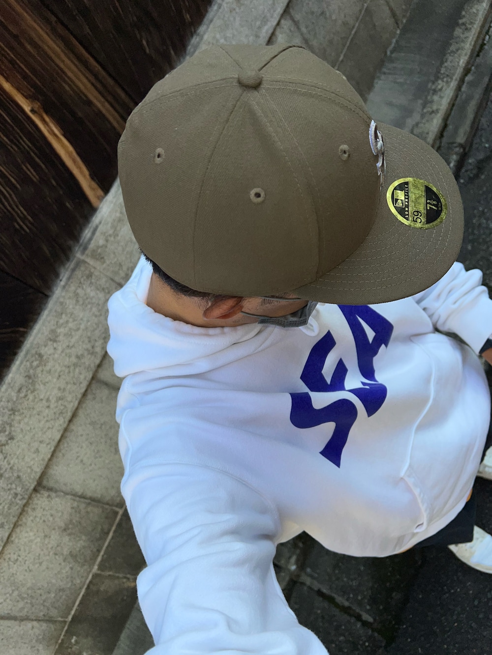 ブルー系のチノパンツ、オレンジ系のTシャツ/カットソー、ホワイト系のパーカーを着用したメンズの秋コーディネートの3枚目の写真