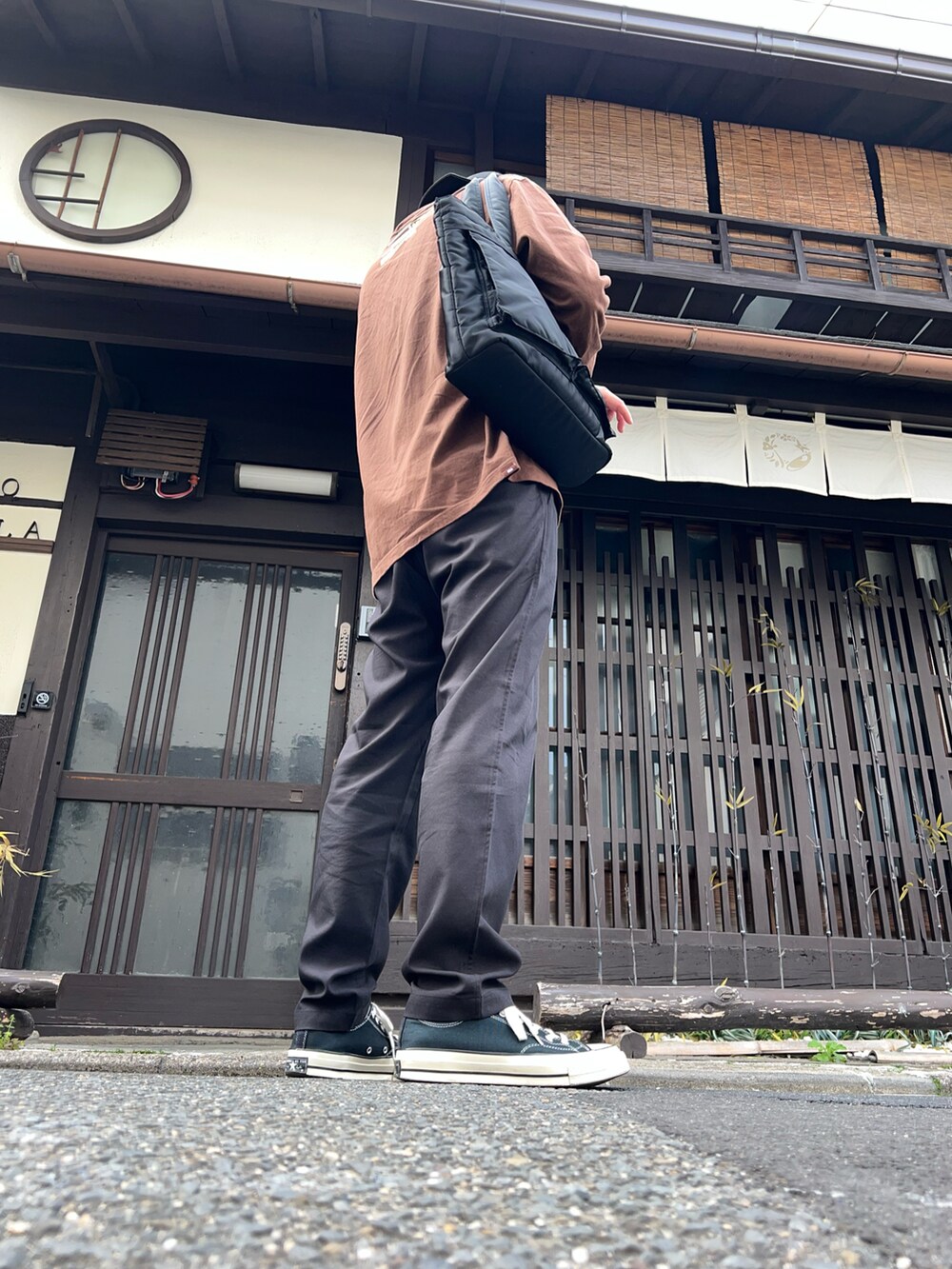 ブラック系のセットアップ、ブラウン系のTシャツ/カットソー、ブラック系のスニーカーを着用したメンズの春コーディネートの2枚目の写真