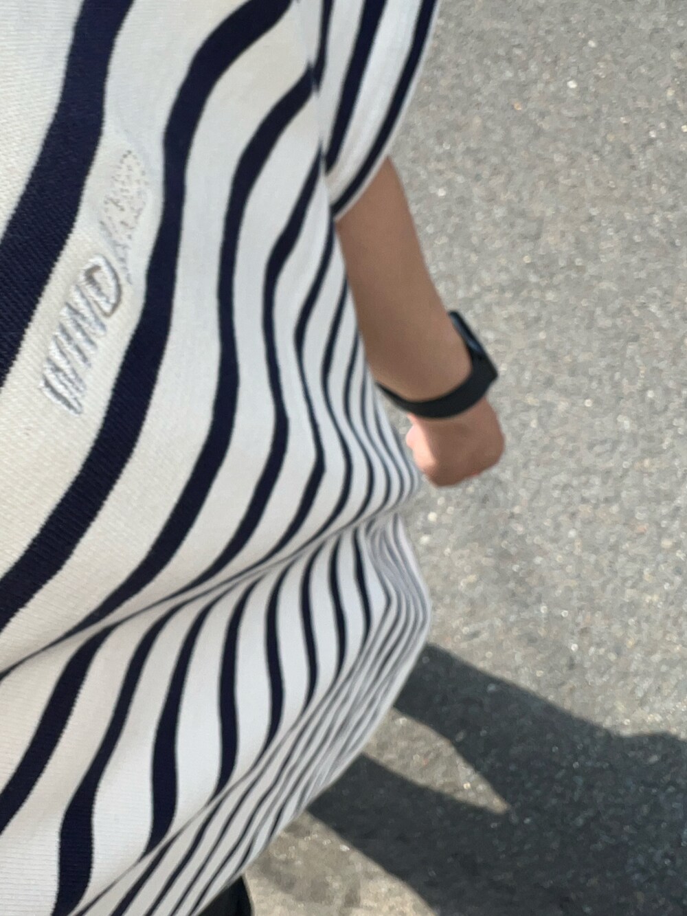 グリーン系のチノパンツ、ブラック系のスニーカー、ブルー系のTシャツ/カットソーを着用したメンズの春コーディネートの3枚目の写真