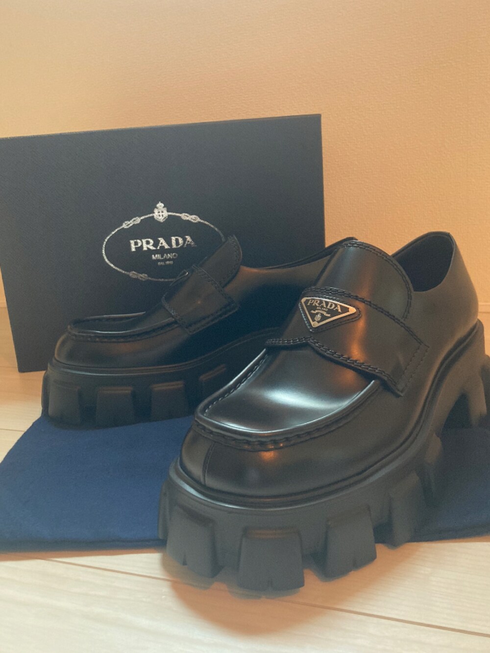 ブラック系のトートバッグ、ブラック系のチェスターコート、ブラック系のローファーを着用したメンズの冬コーディネートの2枚目の写真