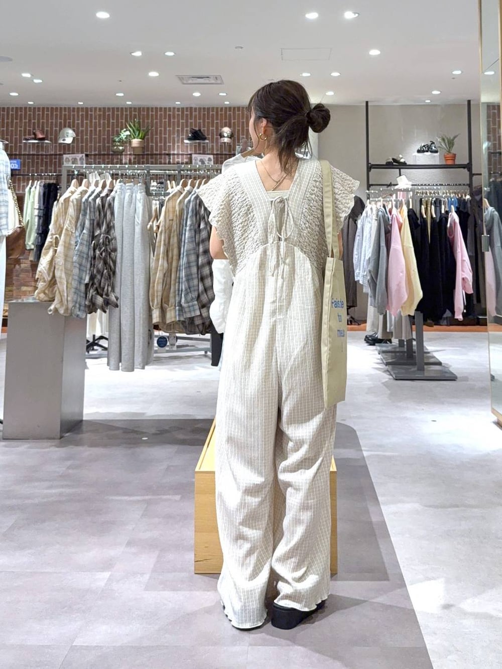 ベージュ系のサロペット/オーバーオール、ゴールド系のタンクトップ、ベージュ系のトートバッグを着用したレディースの春コーディネートの2枚目の写真