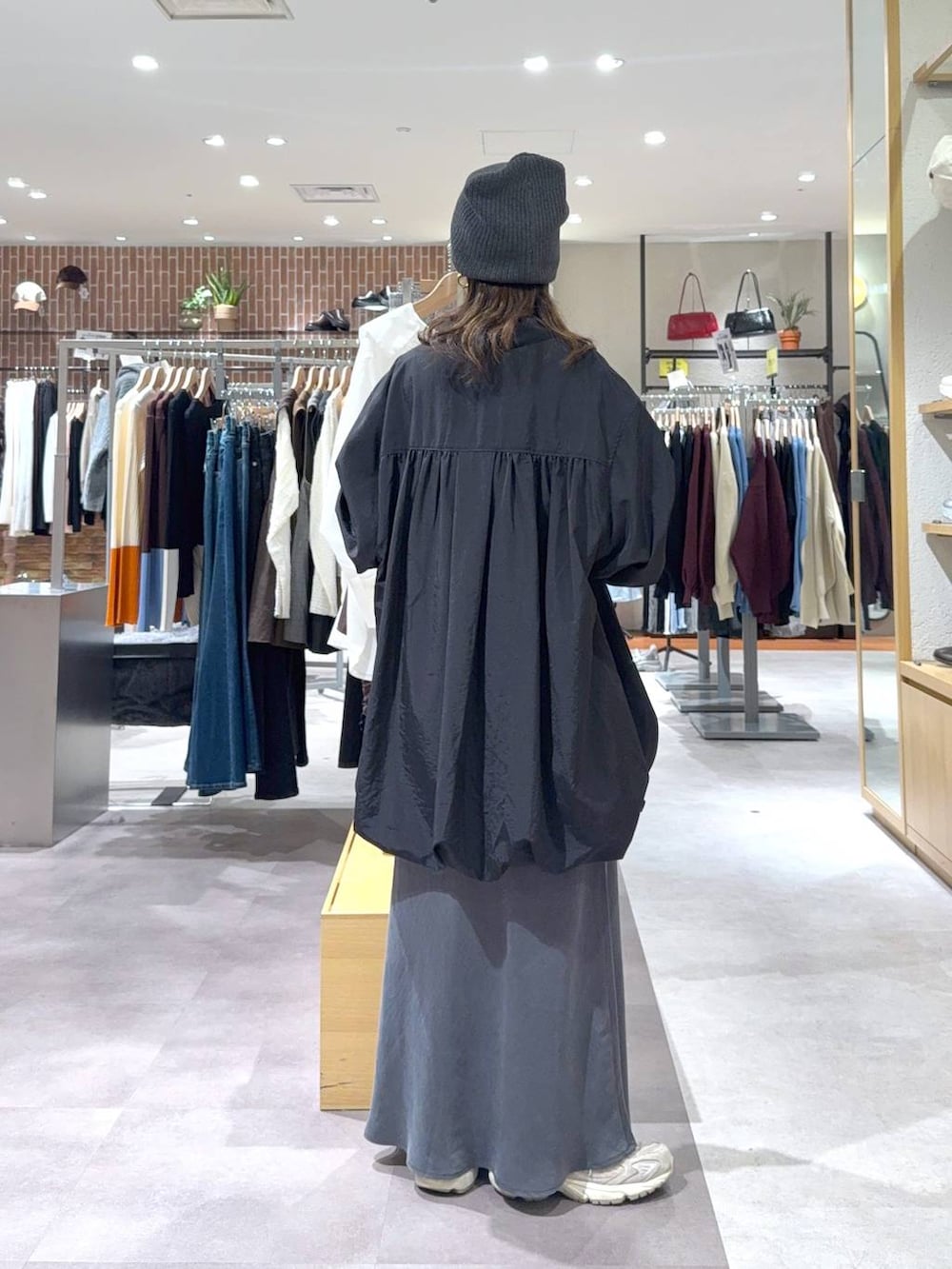 グレー系のスカート、ブラック系のシャツ/ブラウス、グレー系のニットキャップ/ビーニーを着用したレディースの秋コーディネートの2枚目の写真