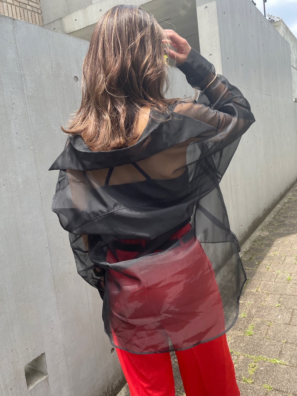 オレンジ系のパンツ、ブラック系のシャツ/ブラウスを着用したレディースの春コーディネートの2枚目の写真