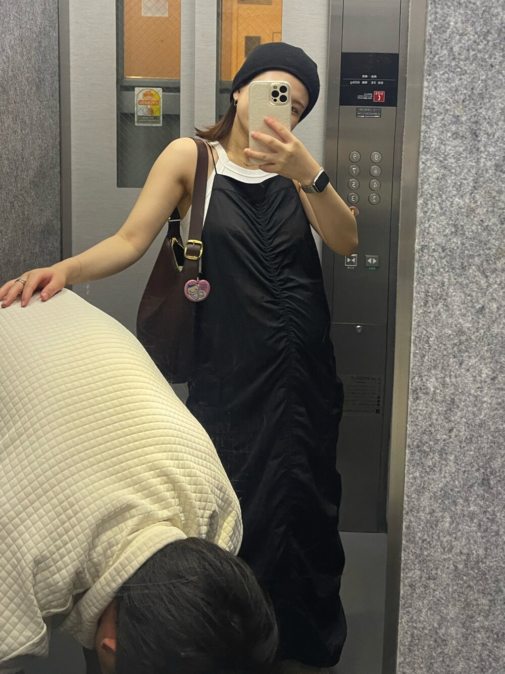 ブラック系のワンピース、ホワイト系のスニーカー、ホワイト系のスニーカーを着用したレディースの夏コーディネートの2枚目の写真