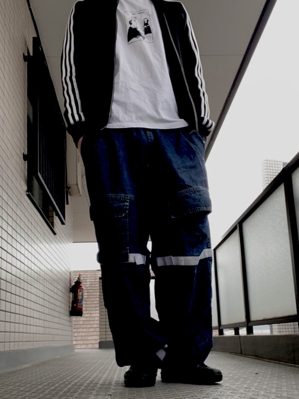 ブラック系のトレンチコート、ブラック系のパンツ、ブラック系のスリッポンを着用したメンズの夏コーディネートの2枚目の写真