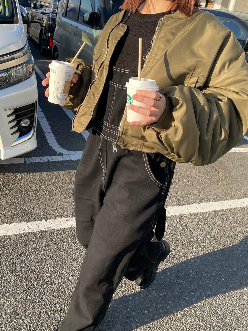 ブラック系のシューズ、ブラック系のオールインワン・サロペット、グリーン系のジャケット/アウターを着用したレディースの冬コーディネートの3枚目の写真