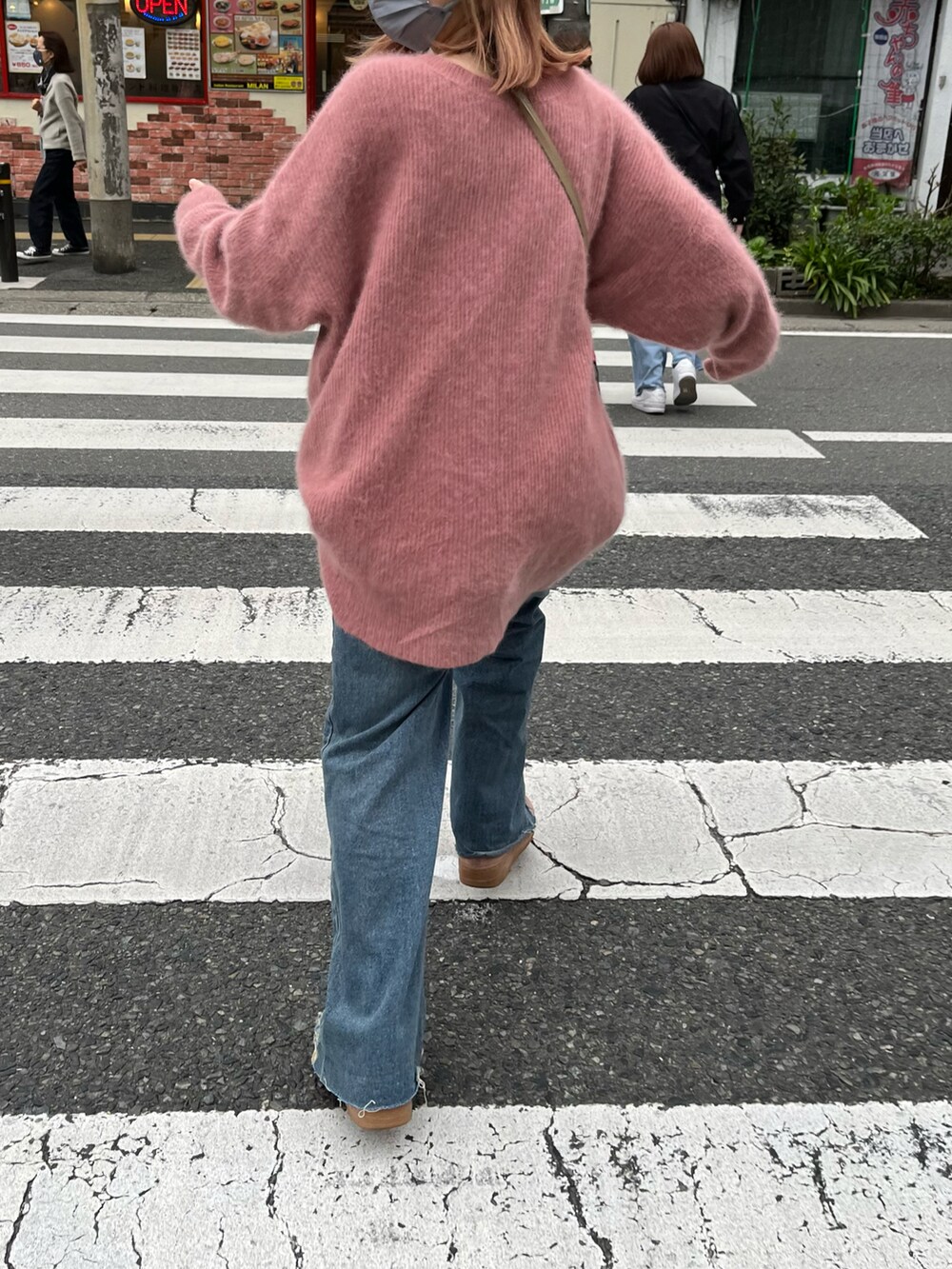 ピンク系のニット/セーター、ベージュ系のショルダーバッグ、グレー系のキャップを着用したレディースの春コーディネートの2枚目の写真