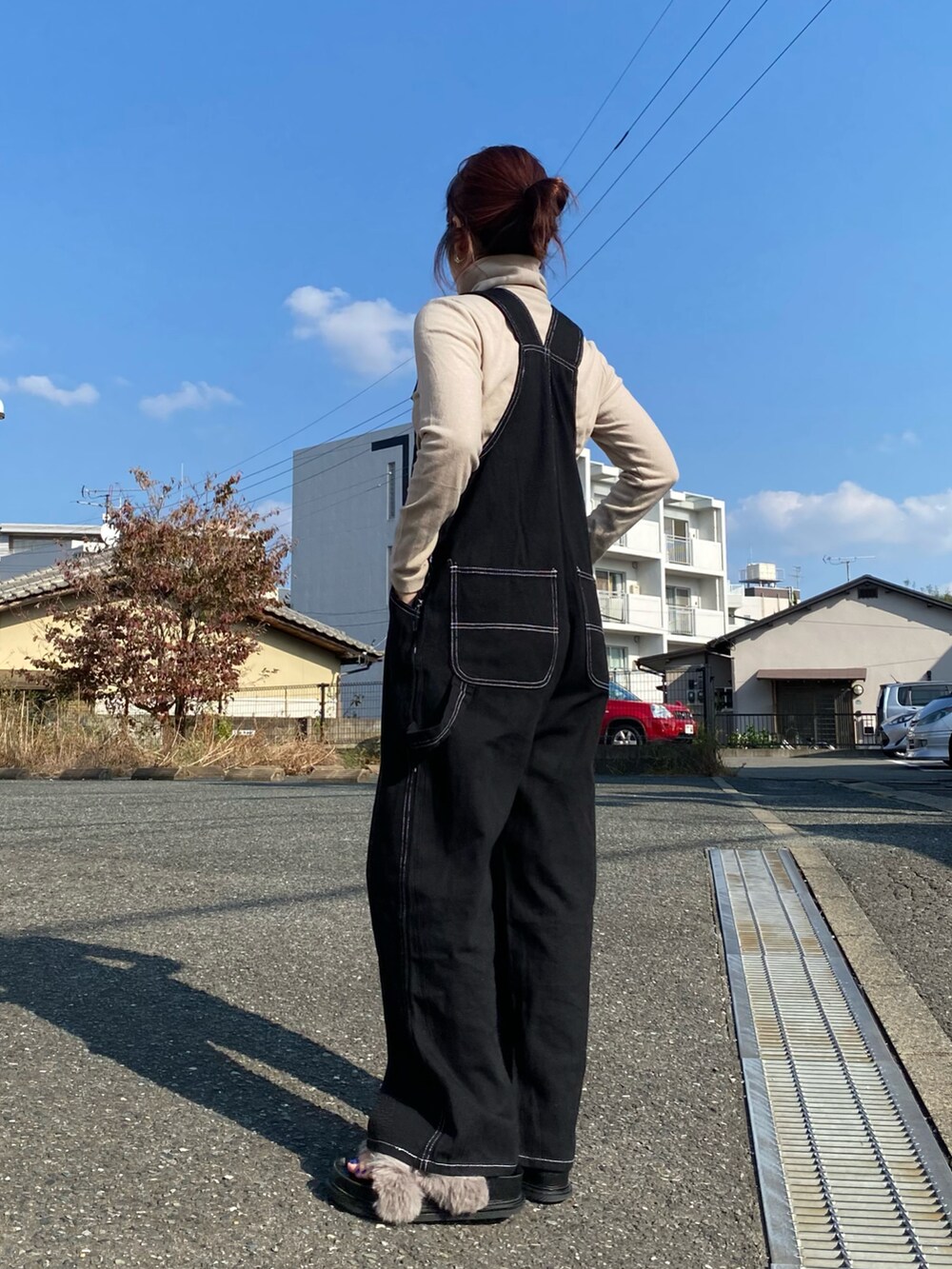 グレー系のシューズ、ブラック系のオールインワン・サロペット、ベージュ系のTシャツ/カットソーを着用したレディースの秋コーディネートの4枚目の写真