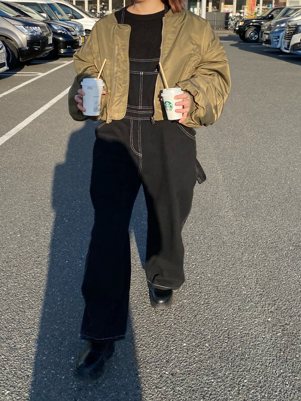 ブラック系のシューズ、ブラック系のオールインワン・サロペット、グリーン系のジャケット/アウターを着用したレディースの冬コーディネートの2枚目の写真