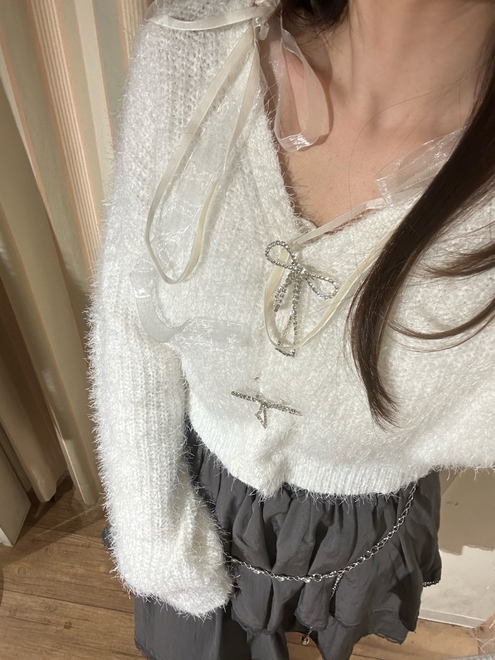 ホワイト系のカーディガン/ボレロ、ホワイト系のキャミソール、シルバー系のショルダーバッグを着用したレディースの秋コーディネートの5枚目の写真