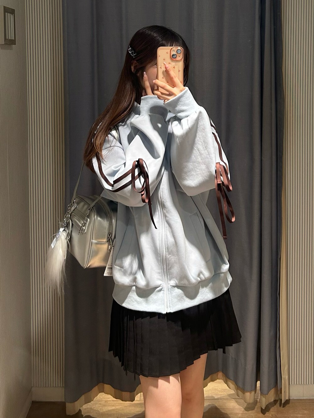 ブラック系のスカート、ブルー系のジャージ、ブラック系のブーツを着用したレディースの秋コーディネートの4枚目の写真