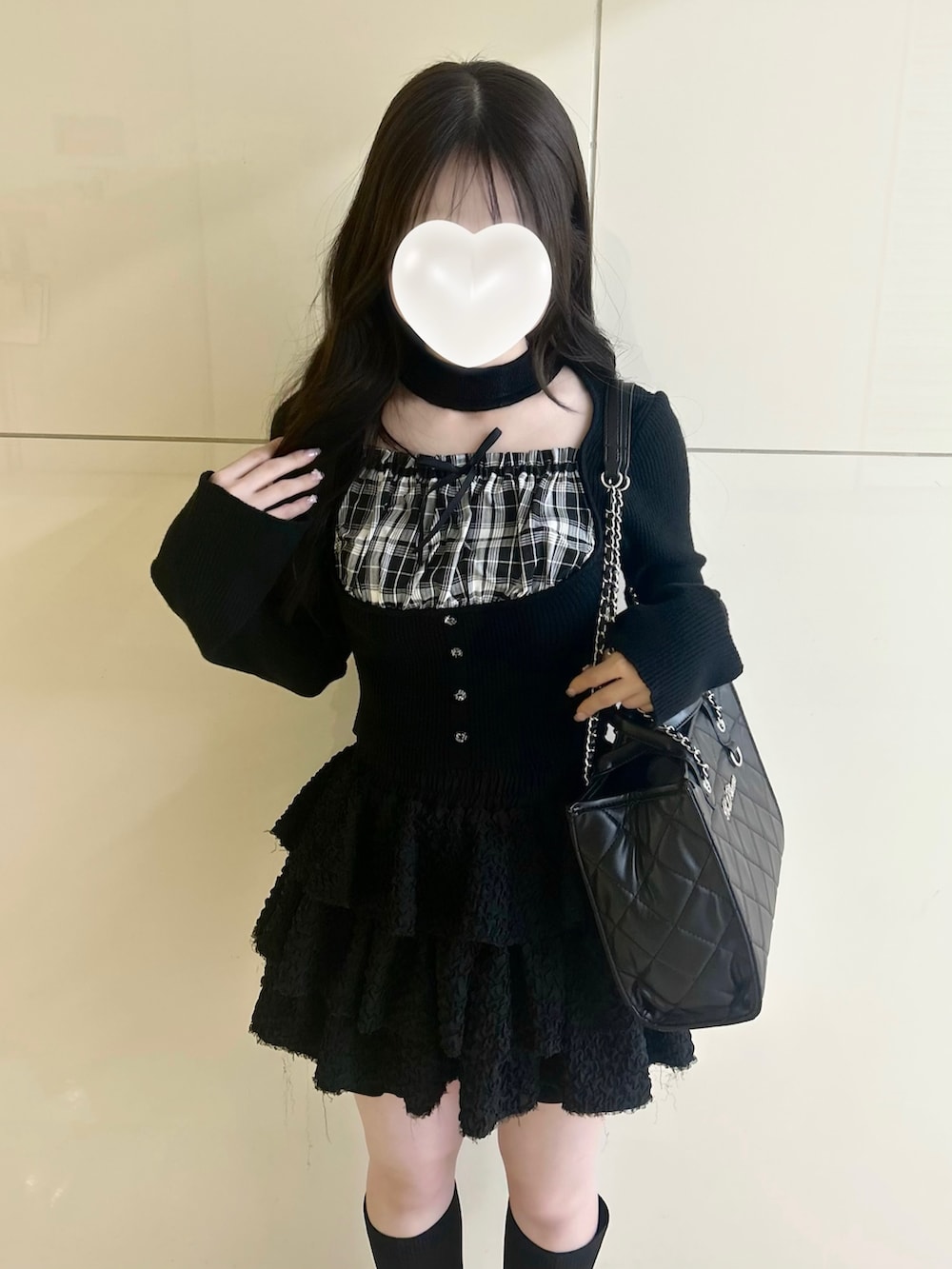 ブラック系のニット/セーター、ブラック系のスカート、ブラック系のトートバッグを着用したレディースの春コーディネートの6枚目の写真