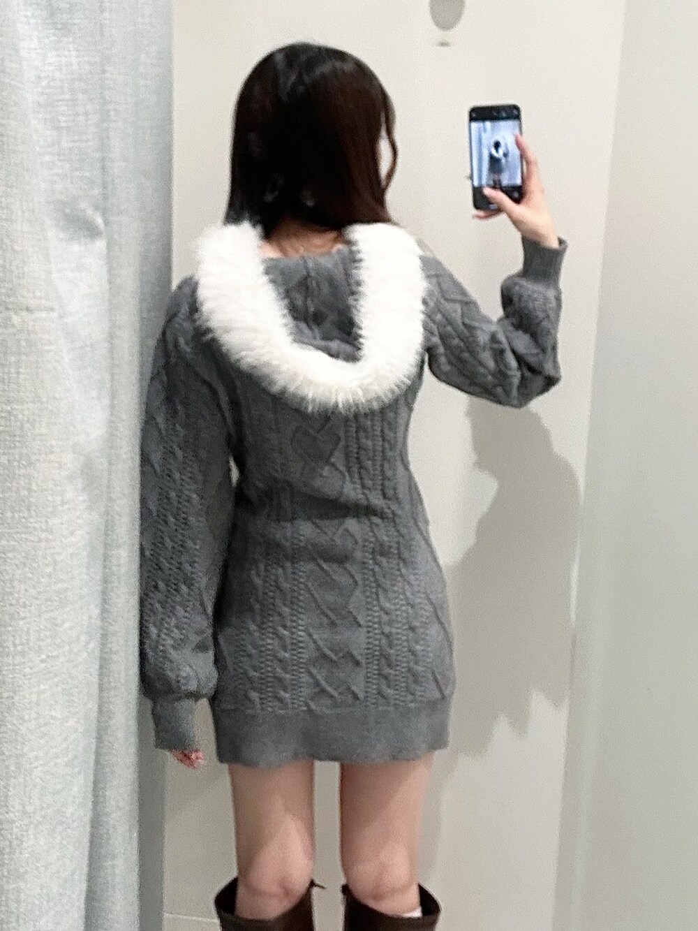 グレー系のワンピース、ホワイト系のトートバッグ、ブラウン系のブーツを着用したレディースの秋コーディネートの6枚目の写真