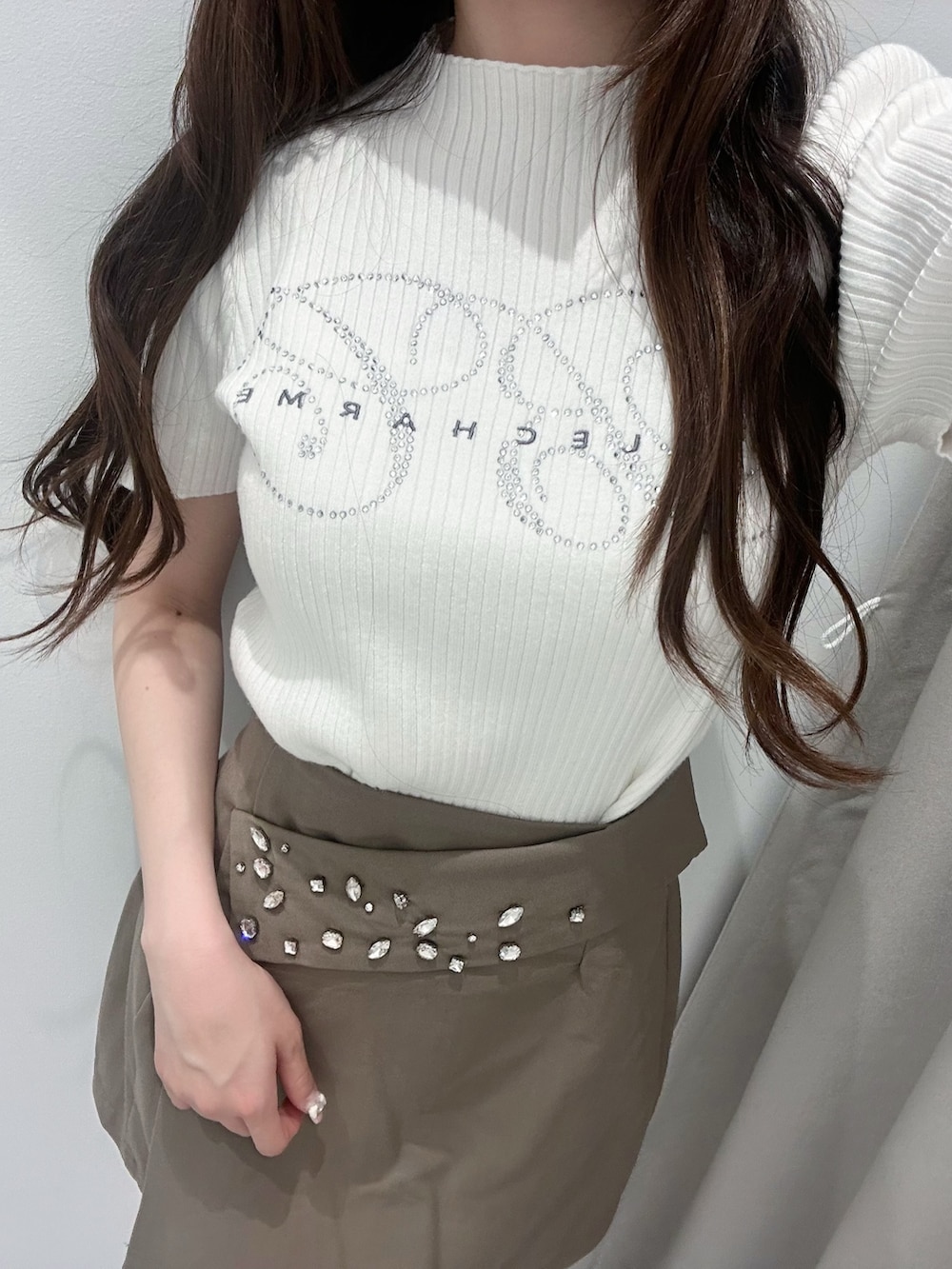 ブラウン系のスカート、ホワイト系のニット/セーター、ホワイト系のドレスシューズを着用したレディースの春コーディネートの5枚目の写真