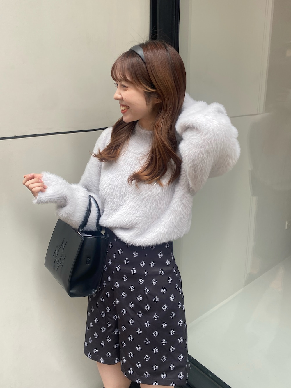 ブラック系のショルダーバッグ、ブラック系のパンツ、ブルー系のニット/セーターを着用したレディースの秋コーディネートの4枚目の写真