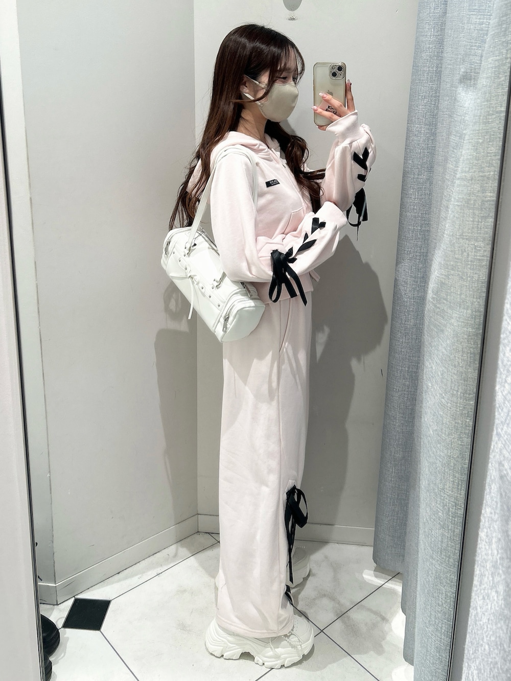 ホワイト系のスニーカー、ピンク系のスウェットパンツ、ピンク系のパーカーを着用したレディースの冬コーディネートの3枚目の写真