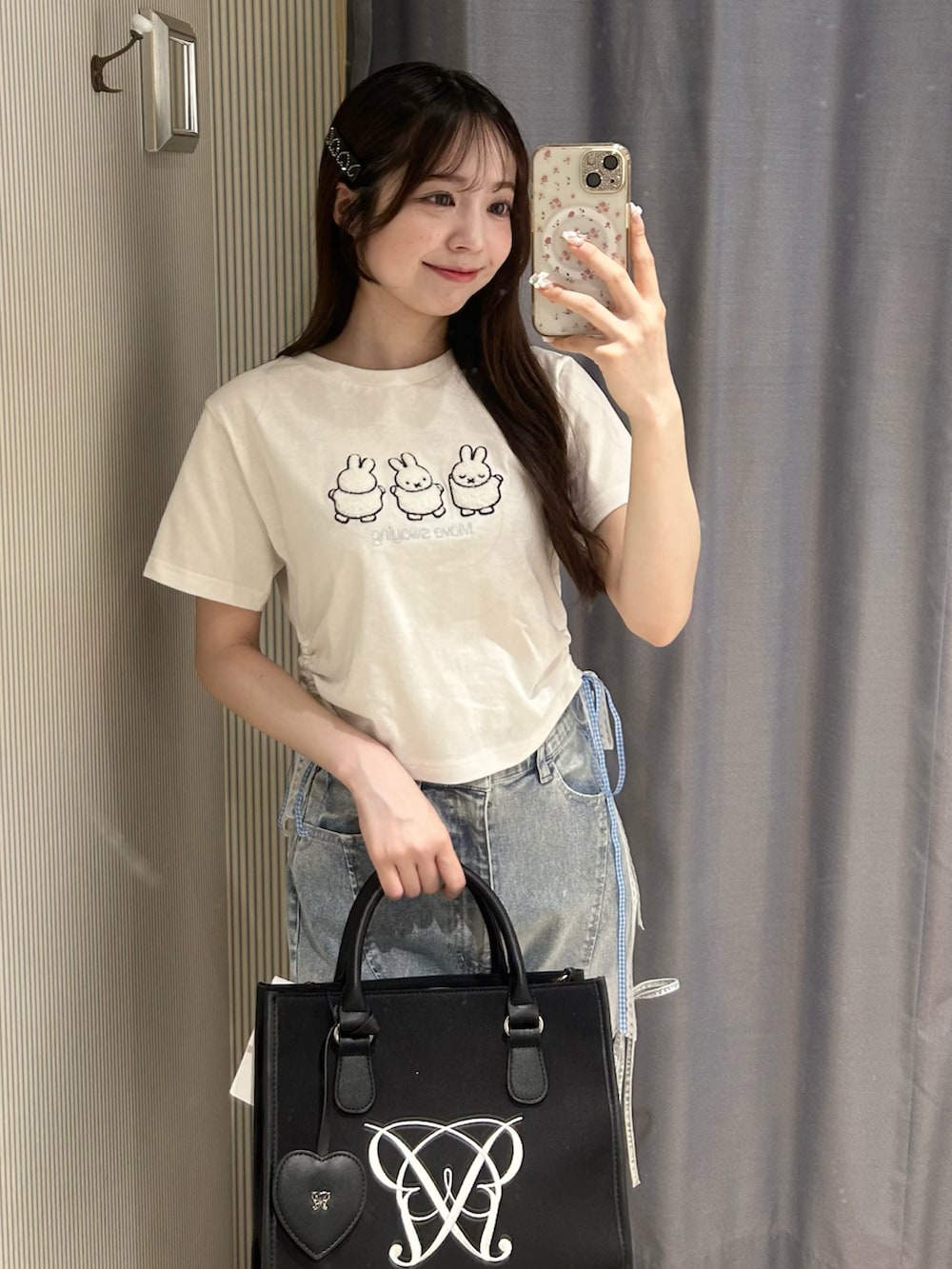 ホワイト系のTシャツ/カットソー、ブラック系のデニムパンツ、ブラック系のトートバッグを着用したレディースの春コーディネートの2枚目の写真