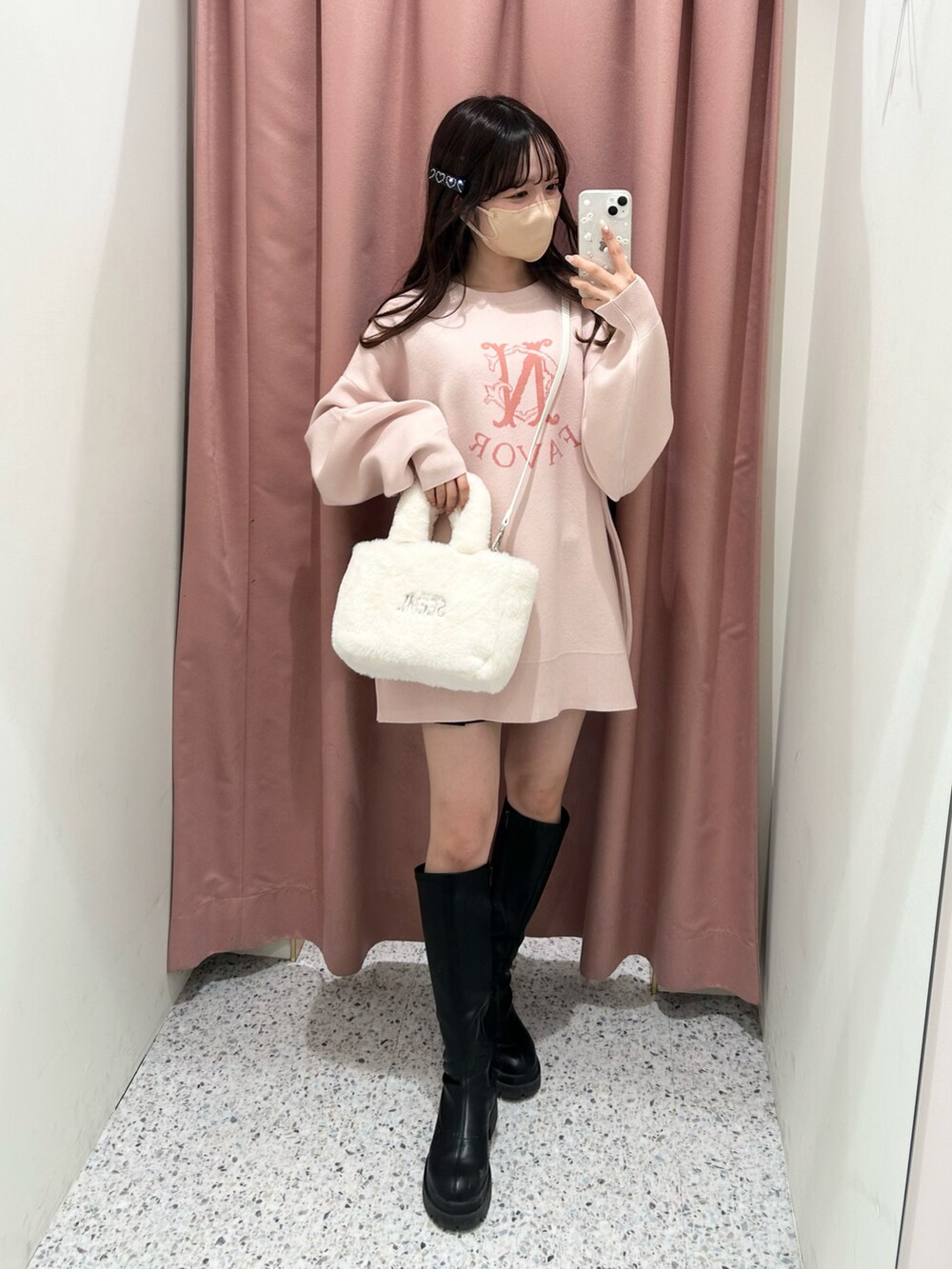 ピンク系のニット/セーター、ホワイト系のトートバッグ、ブラック系のブーツを着用したレディースの冬コーディネートの2枚目の写真