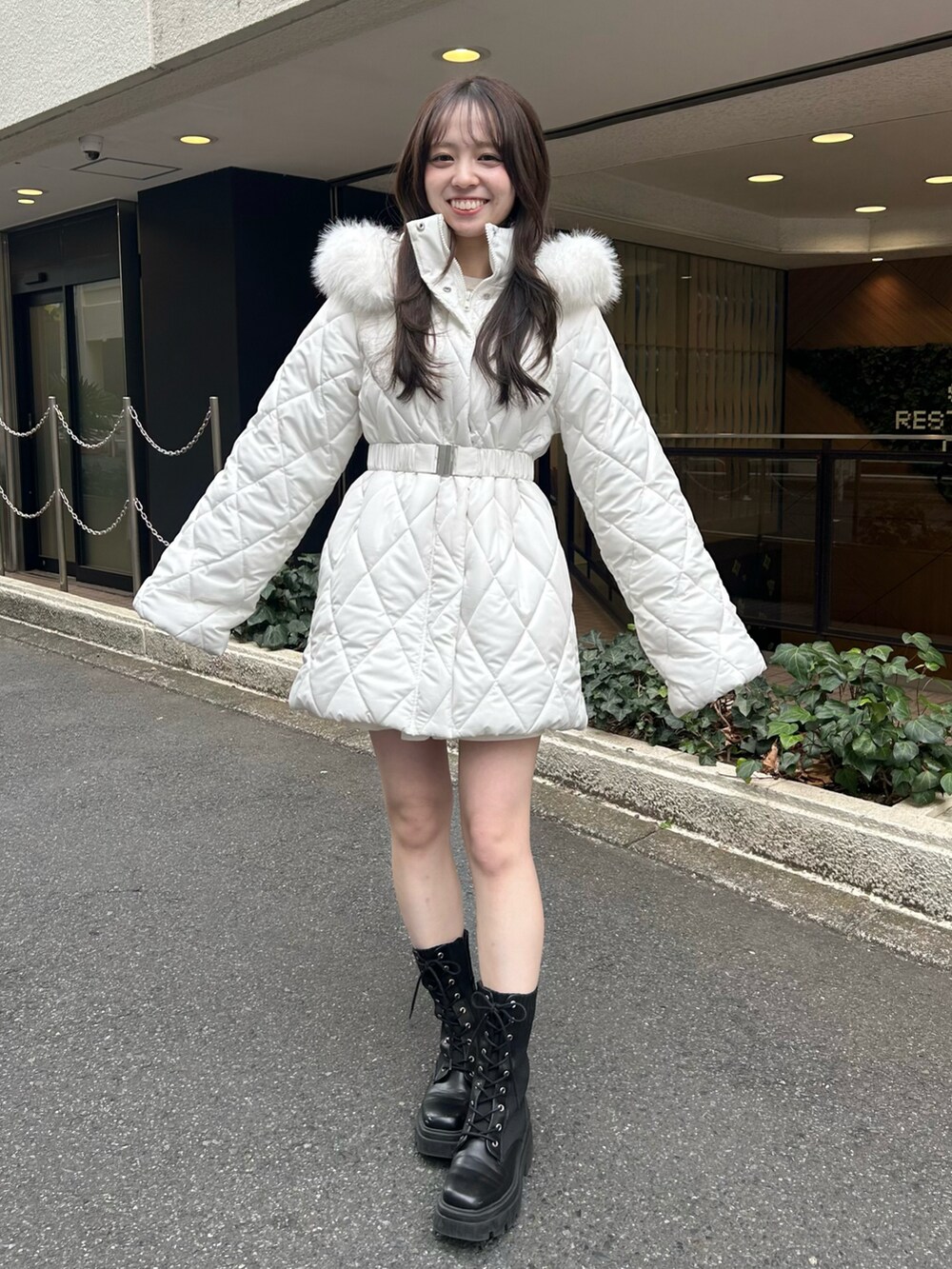 ブラック系のブーツ、ホワイト系のスカート、ホワイト系のその他アウターを着用したレディースの秋コーディネートの2枚目の写真