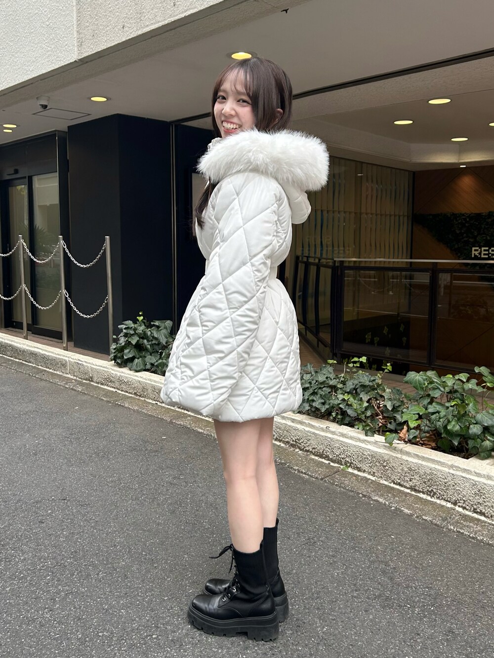 ブラック系のブーツ、ホワイト系のスカート、ホワイト系のその他アウターを着用したレディースの秋コーディネートの4枚目の写真