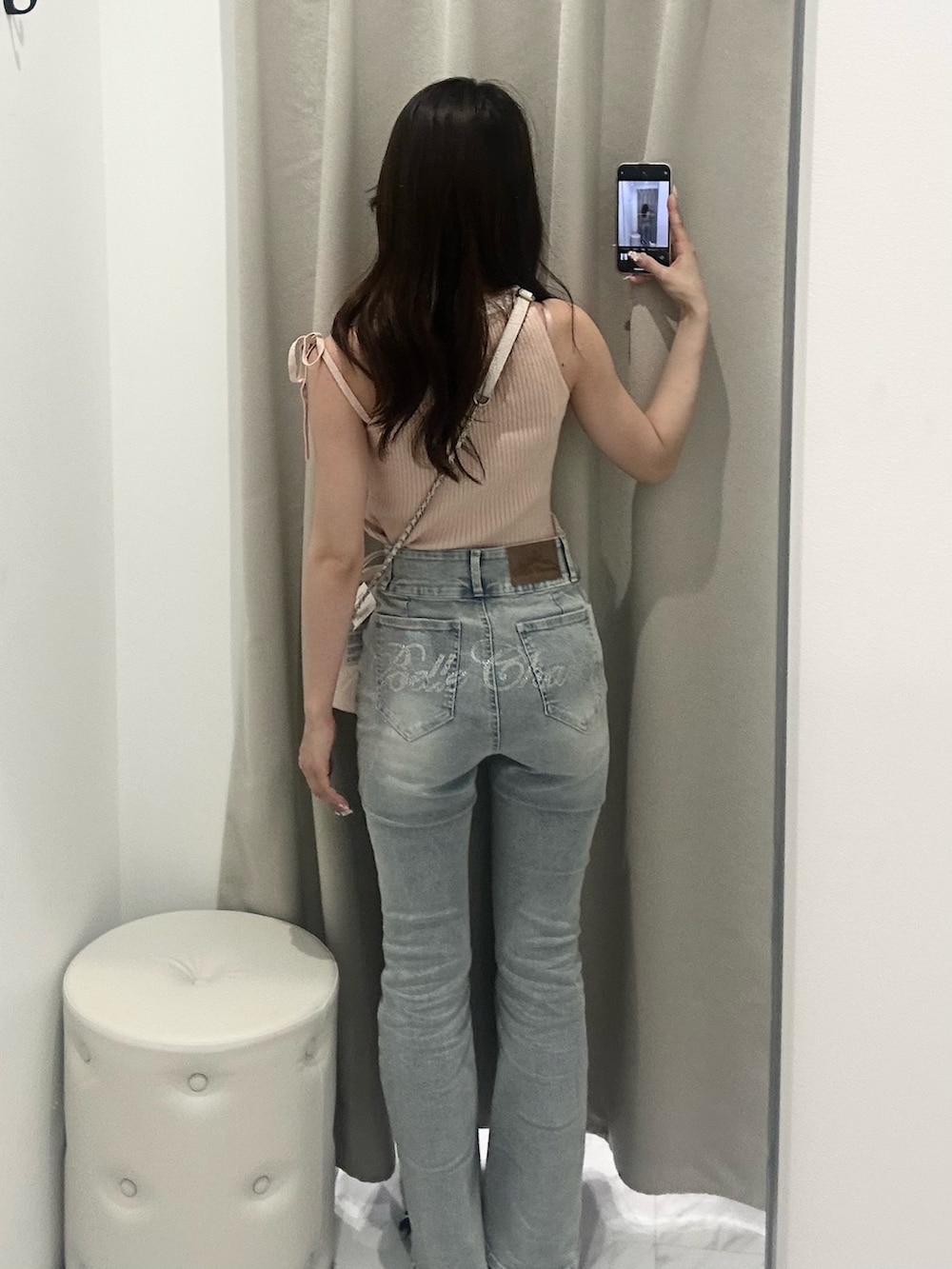 ピンク系のアンサンブル、ホワイト系のショルダーバッグ、ブルー系のデニムパンツを着用したレディースの夏コーディネートの3枚目の写真