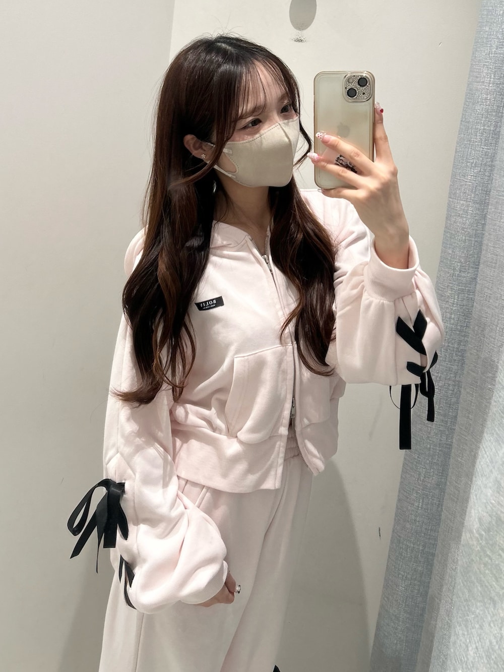 ホワイト系のスニーカー、ピンク系のスウェットパンツ、ピンク系のパーカーを着用したレディースの冬コーディネートの8枚目の写真