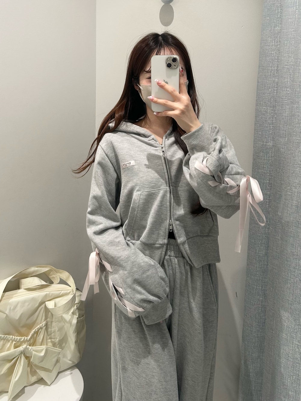 グレー系のスウェットパンツ、グレー系のパーカー、イエロー系のボストンバッグを着用したレディースの冬コーディネートの3枚目の写真