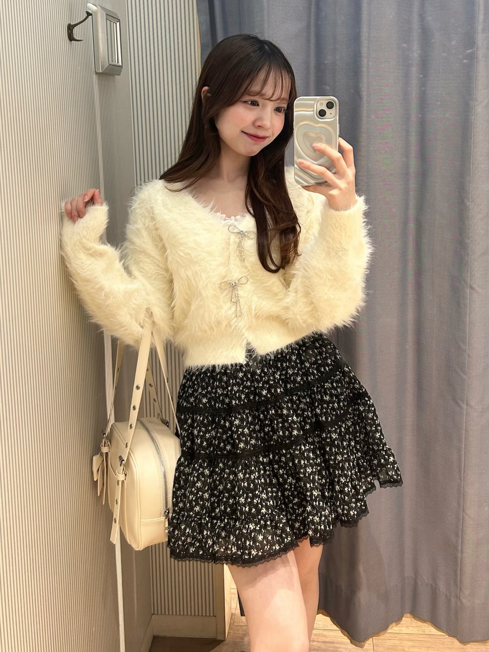 ホワイト系のショルダーバッグ、ホワイト系のカーディガン/ボレロ、その他のスカートを着用したレディースの冬コーディネートの3枚目の写真