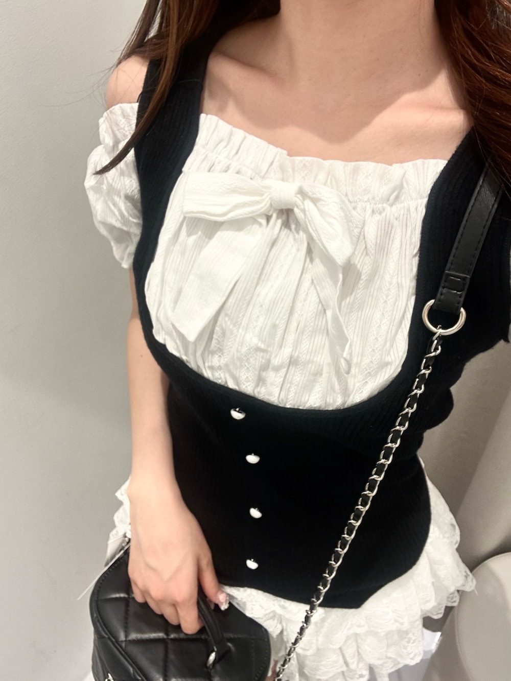 ブラック系のニット/セーター、ホワイト系のスカート、ブラック系のショルダーバッグを着用したレディースの夏コーディネートの6枚目の写真