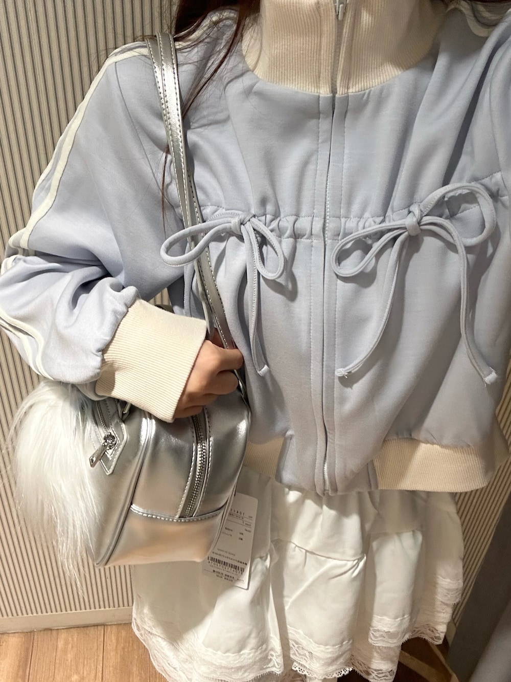 ホワイト系のスカート、ブラック系のスウェット、ホワイト系のスニーカーを着用したレディースの秋コーディネートの5枚目の写真