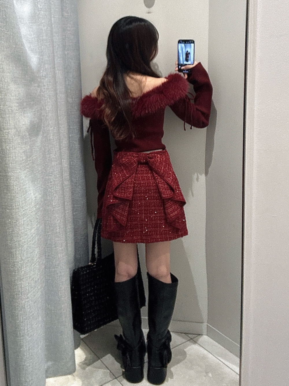 ブラック系のトートバッグ、レッド系のトップス、レッド系のスカートを着用したレディースの秋コーディネートの5枚目の写真