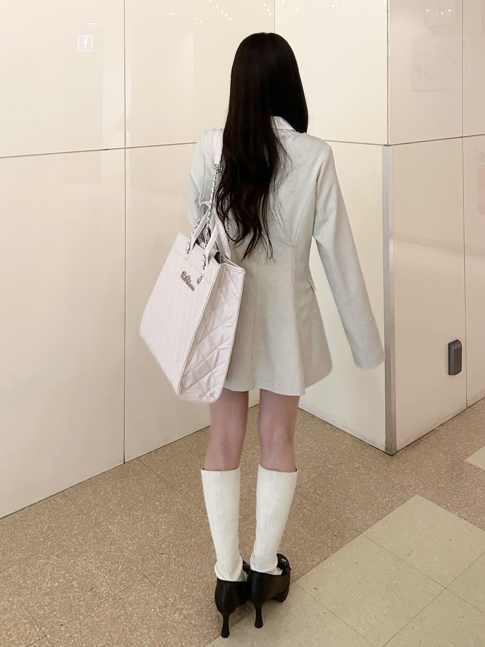 ホワイト系のノーカラージャケット、ホワイト系のその他パンツ、ホワイト系のトートバッグを着用したレディースの春コーディネートの6枚目の写真