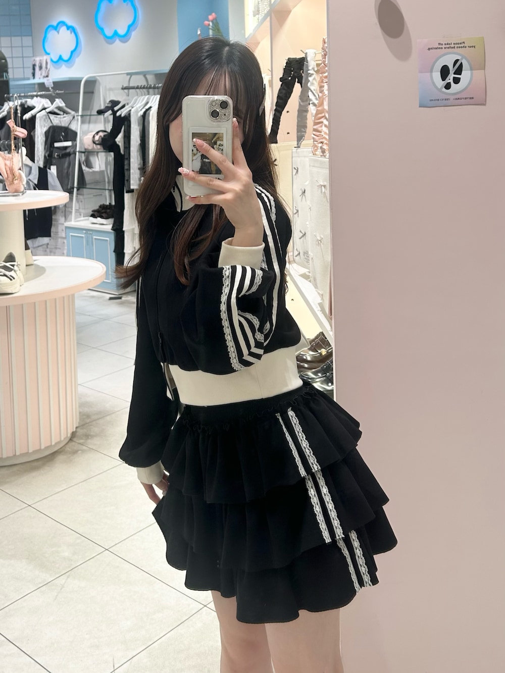 ブラック系のジャージ、ブラック系のスカート、ホワイト系のバッグを着用したレディースの夏コーディネートの2枚目の写真