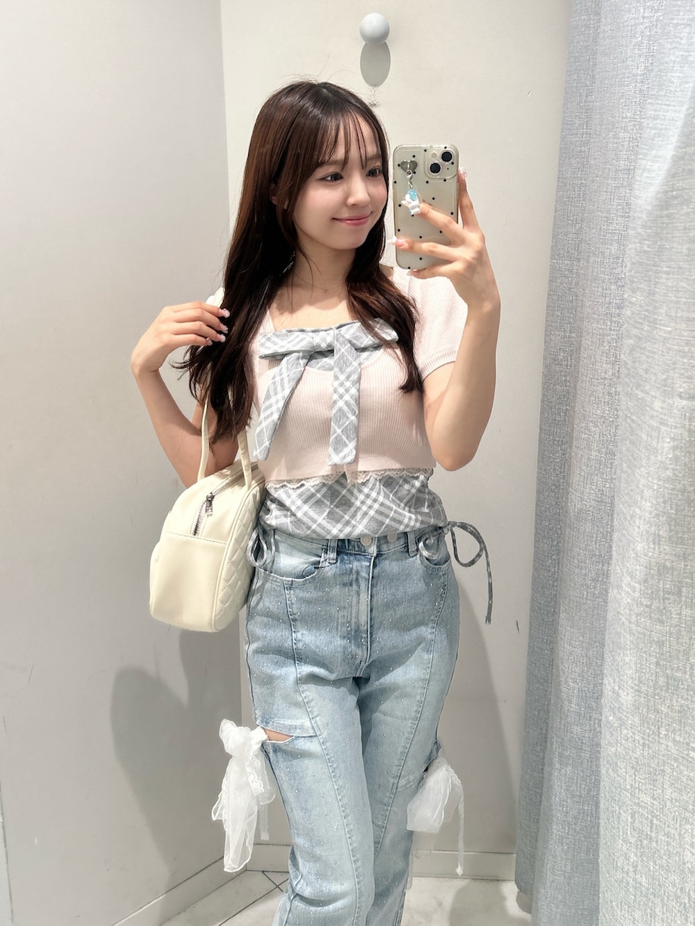 ブルー系のデニムパンツ、ピンク系のワンピース、ホワイト系のスニーカーを着用したレディースの夏コーディネートの2枚目の写真
